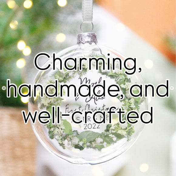 Decorative glass ornament with greenery and great review overlay onto, blurred lights in the background