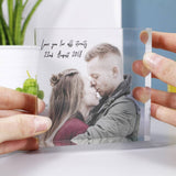 Clear Acrylic block being held with two hands to show the scale of the block. Has a photo of couple and text in a script font which can be personalised 